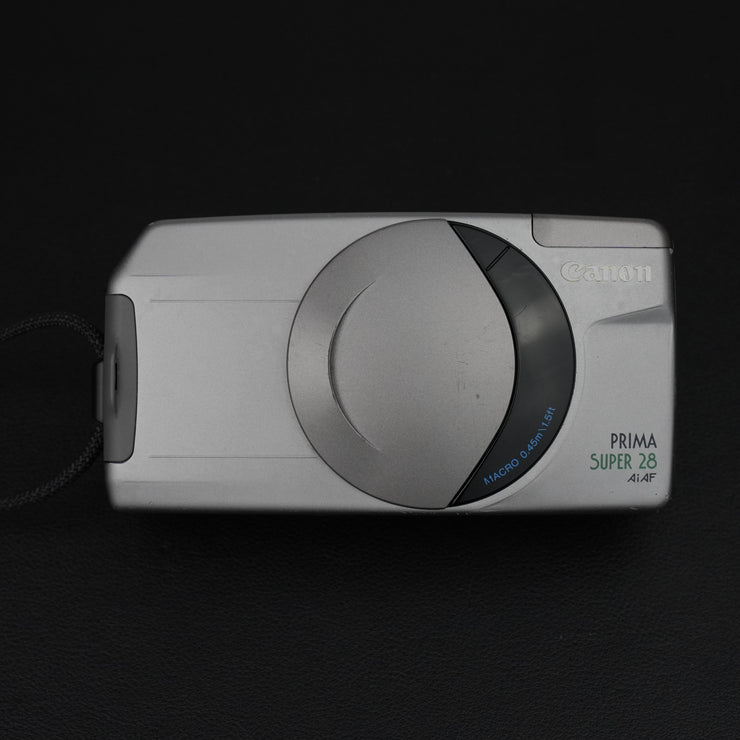Vista frontale della fotocamera Canon Prima Super 28 AI AF con sportellino chiuso, design compatto e elegante.