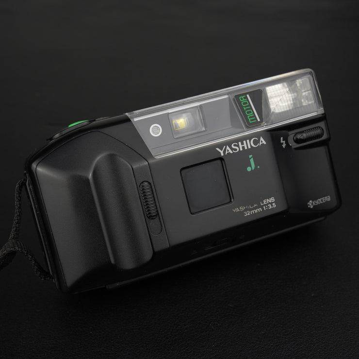 Fotocamera analogica Yashica J-Motor vista frontale con sportellino dell’obiettivo chiuso, design vintage