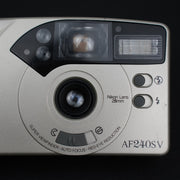 Primo piano dell’obiettivo fisso 28mm della Nikon AF240SV, compatta 35mm