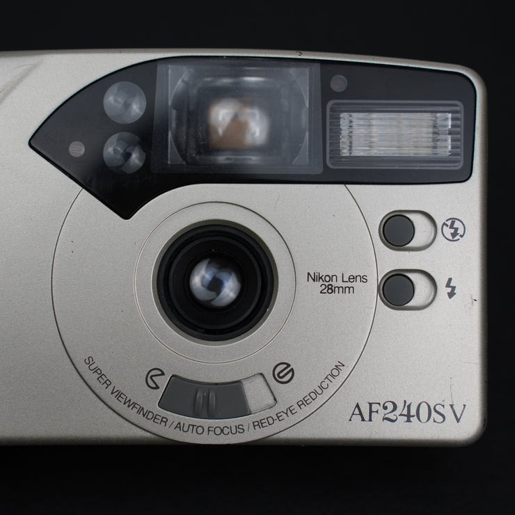 Primo piano dell’obiettivo fisso 28mm della Nikon AF240SV, compatta 35mm