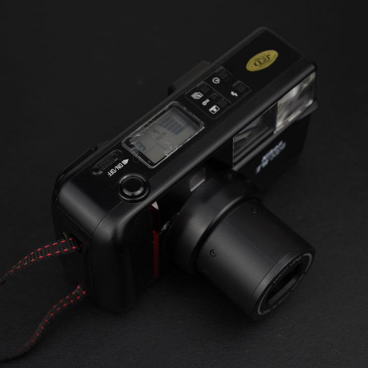 Nikon TW Zoom vista dall’alto con pulsanti di controllo e piccolo display.