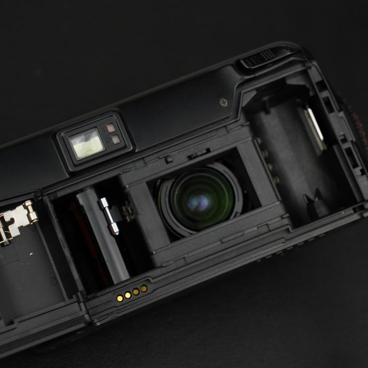 Nikon TW Zoom retro con sportellino aperto che mostra lo scomparto pellicola e lente interna