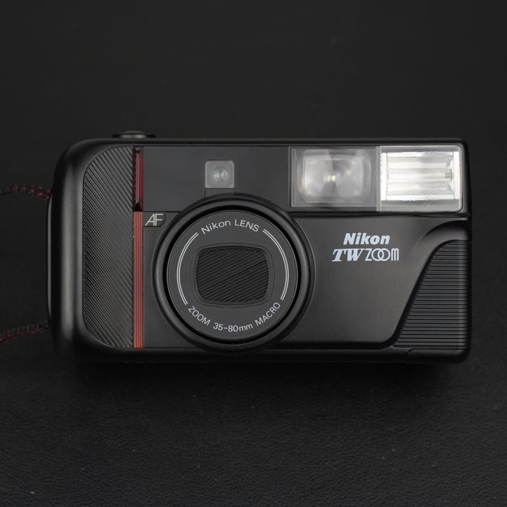 Fotocamera analogica Nikon TW Zoom vista frontale con sportello obiettivo chiuso.