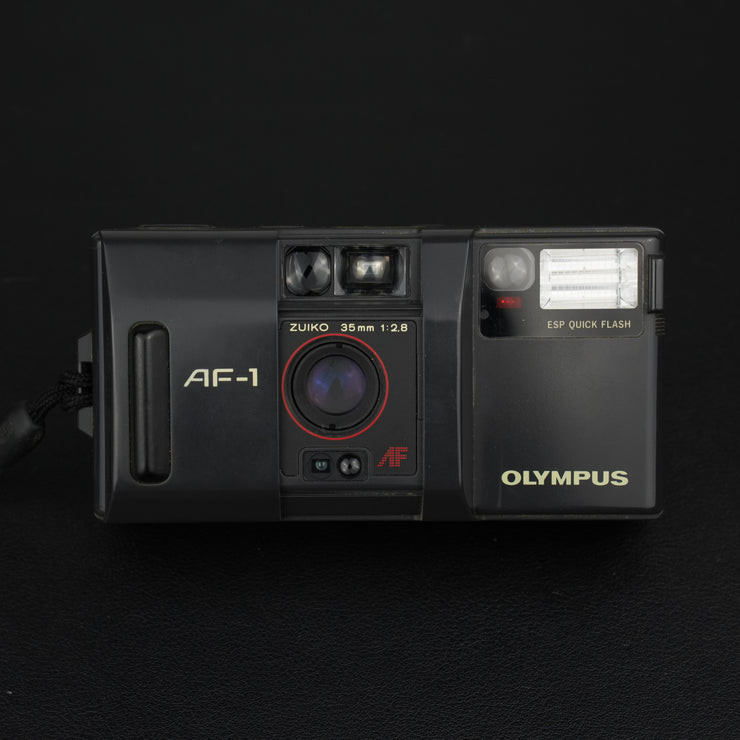 Olympus AF-1 vista frontale con sportellino aperto e obiettivo visibile